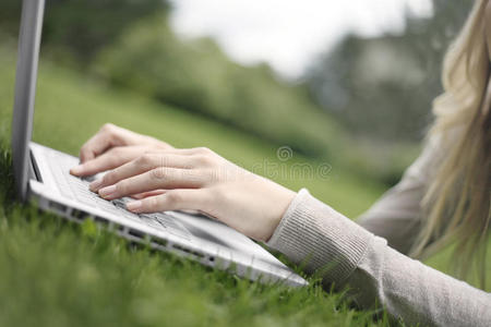 在草地上使用笔记本电脑