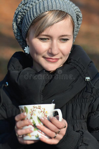 室外端着茶杯的年轻女子