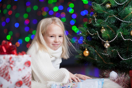 圣诞树下看书的小女孩