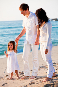 夏日沙滩上有女儿的快乐小家庭