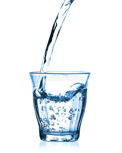 隔离的瓶子里倒水从厨房水龙头往杯子里倒水的女人在厨房的灰色桌子上