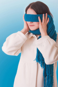 概念图。一个女孩试图躲开外面的世界，用围巾闭上了眼睛