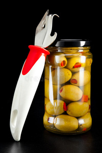 装有罐头橄榄和开罐器的玻璃罐
