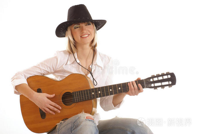 一个年轻的金发女牛仔正在用一把表兄妹的吉他演奏
