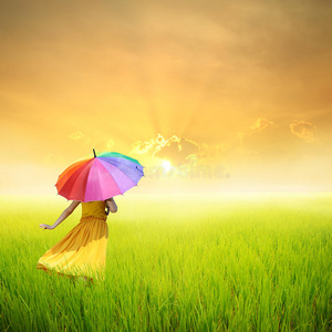 青草地夕阳中撑伞的美女图片