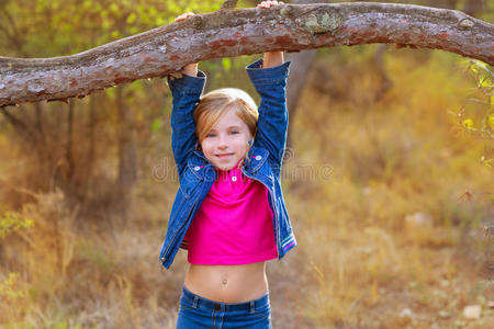小女孩在松林的树干上荡秋千