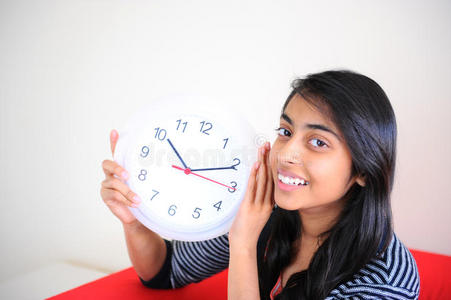 美丽的印度女孩拿着钟