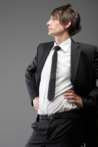 年轻商人黑色西装灰色背景休闲领带