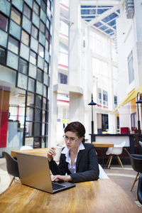 商务女性用笔记本电脑喝咖啡休息
