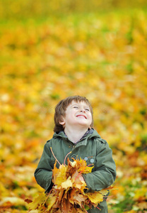 公园里快乐可爱的秋叶男孩