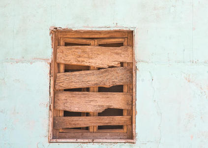 被毁的墙用灰泥用木板封住的窗户照片