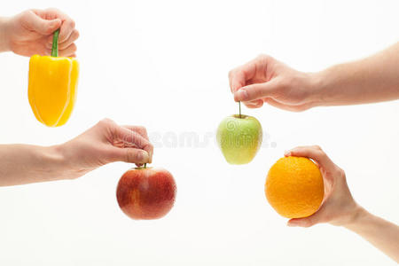 四只手拿着水果和胡椒