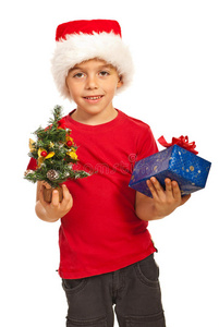 抱着圣诞树和礼物的快乐男孩