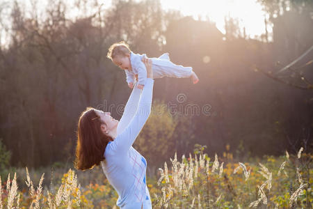 一个阳光明媚的秋日，年轻的母亲和她的孩子玩耍