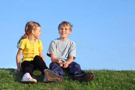 男孩和女孩坐在草地上