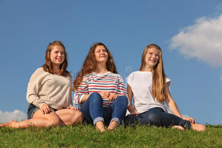 三个赤脚女孩坐在那里遥望远方图片