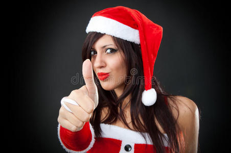 穿圣诞老人衣服的女孩给了一个好的标志