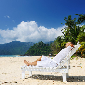 在海滩上放松的男人照片