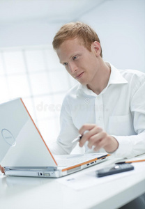 这个年轻人正在用电脑工作。