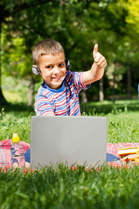 男孩在公园户外用笔记本电脑