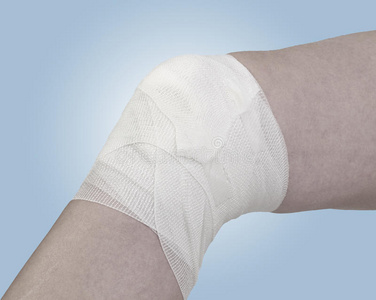 包扎膝盖用棉布包扎膝盖上的伤口.照片