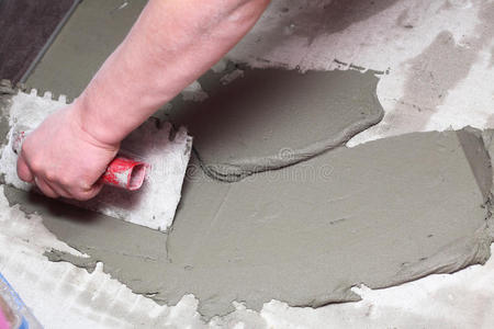 建筑工人正在家里贴瓷砖地板胶照片