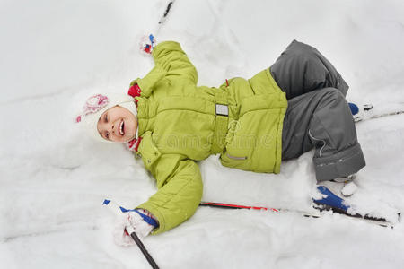 滑雪的女孩，棍子躺在雪地上
