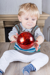 玩红色圣诞树球的幼儿
