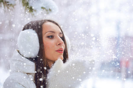 冬天公园里的女人在雪上吹