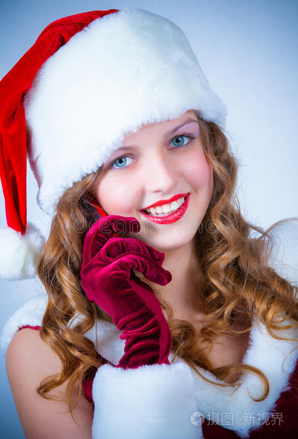 女圣诞老人享受雪天圣诞节和手机