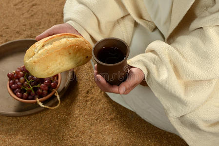 耶稣的手拿着面包和酒
