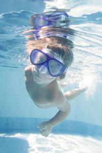 儿童在游泳池中戴着面罩潜水