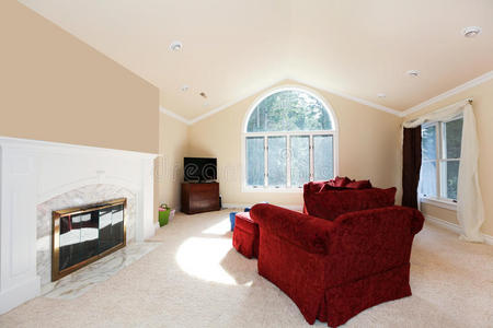 宽敞明亮的客厅，配有红色沙发和白色壁炉。