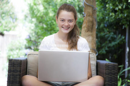 一个年轻女孩在外面用她的笔记本电脑