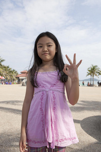 亚洲女孩脸上的手指象征着数字