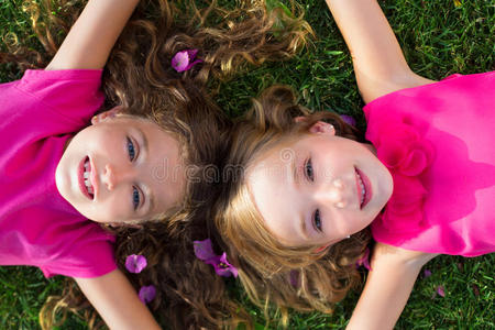 孩子们朋友女孩们躺在花园的草地上微笑着