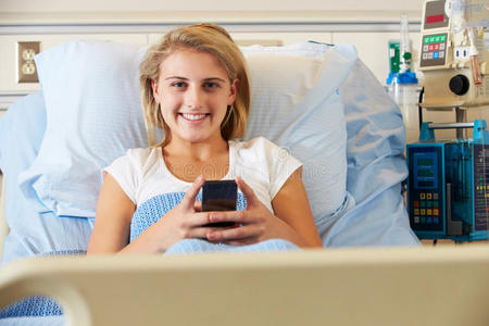 女患者在病床上使用手机图片