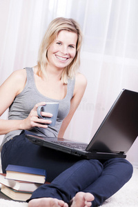 漂亮的金发女人在她的公寓里上网。