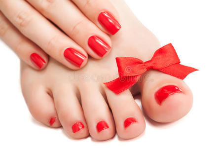 红色指甲和带蝴蝶结的足部护理.孤立的照片