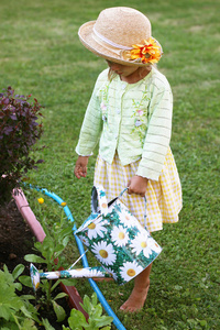 可爱的小女孩在花园里浇花