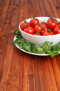 樱桃西红柿装在一个碗里，周围是绿色的莴苣