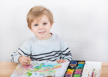 一个可爱的两年小男孩正在享受绘画的乐趣