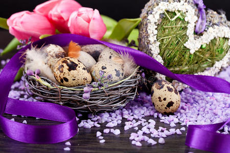 粉红郁金香和棕色彩蛋配紫色彩带复活节装饰