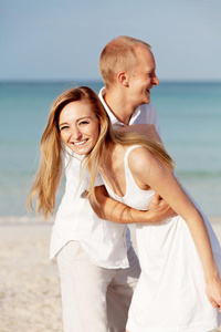 恋爱中的幸福夫妻在海滩上玩得开心