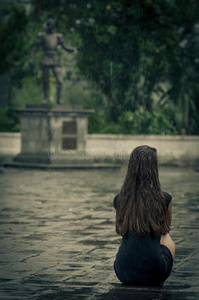 坐在雨中的女人，穿着黑色的小裙子