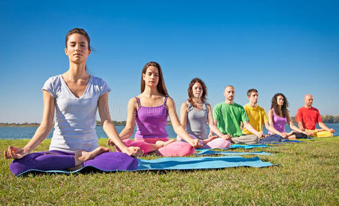 一群年轻人在瑜伽课上冥想。