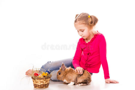 带着复活节兔子和彩蛋的快乐小女孩。复活节快乐