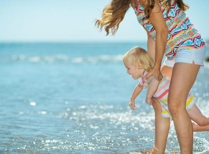 母亲和女婴在海边玩耍