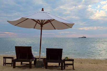 日落时海滩上有两张床和一把伞