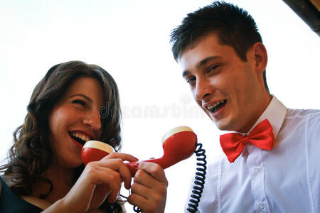 一对漂亮的夫妇对着红色的电话交谈